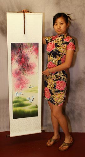 Yang Chen holds a four seasons cranes landscape wall scroll